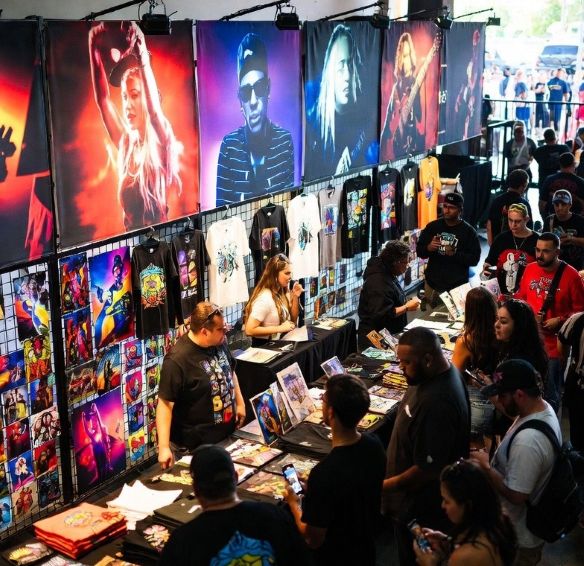 merch booth at a concert illuminated by vibrant backlit graphics